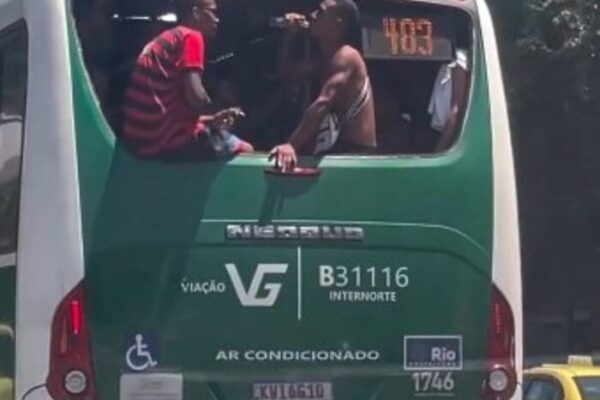 Dois homens ficam sentados em janela sem vidro em ônibus do Rio de Janeiro