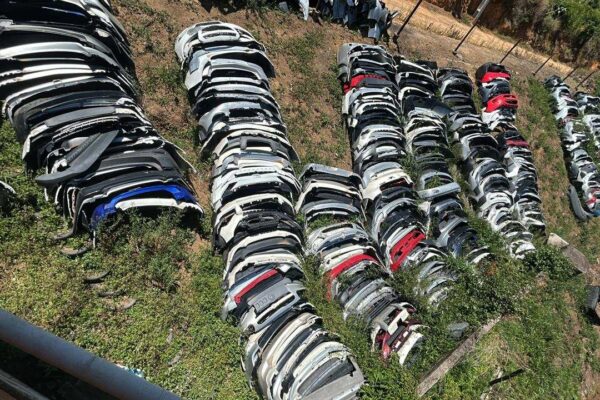 Acervo de para-choques automotivos empilhados em ferro-velho, apreendidos em operação de desmonte.