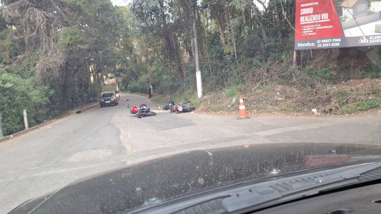 Acidente de moto em Nova Friburgo, bairro Nova Suíça. Motos caídas na rua após colisão.