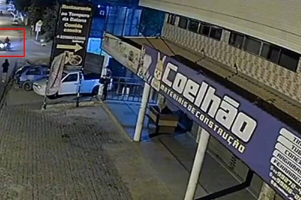 Acidente de trânsito em Nova Friburgo: carro e moto colidem à noite, registrado por câmera de segurança.