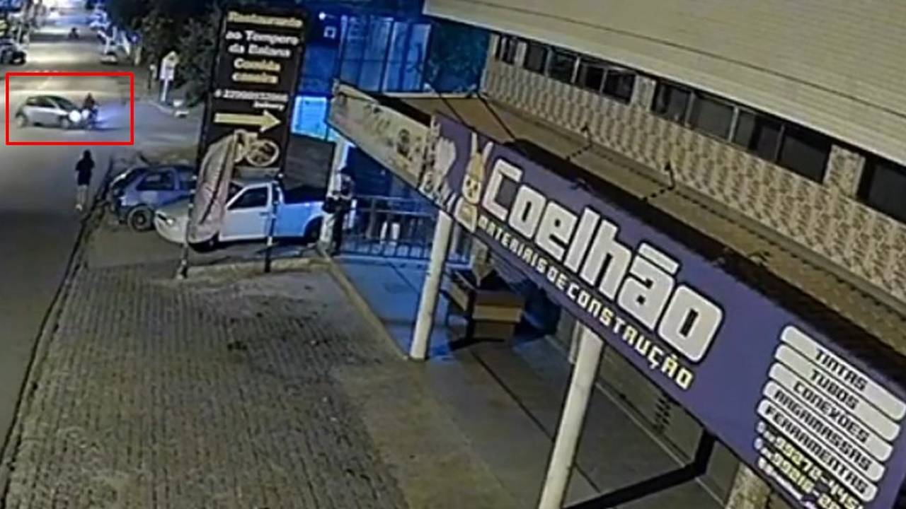 Acidente de trânsito em Nova Friburgo: carro e moto colidem à noite, registrado por câmera de segurança.