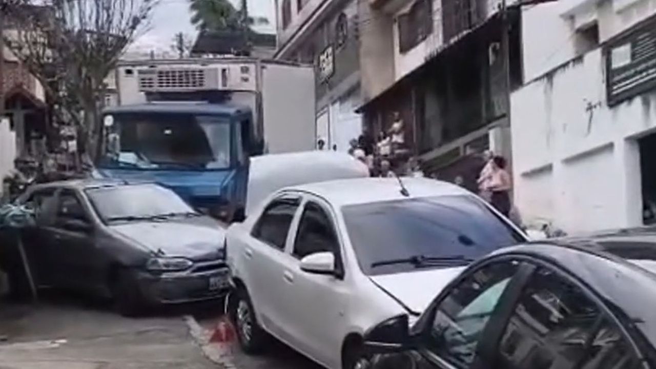 Acidente em Nova Friburgo: caminhão atinge carros em via estreita, causando danos.