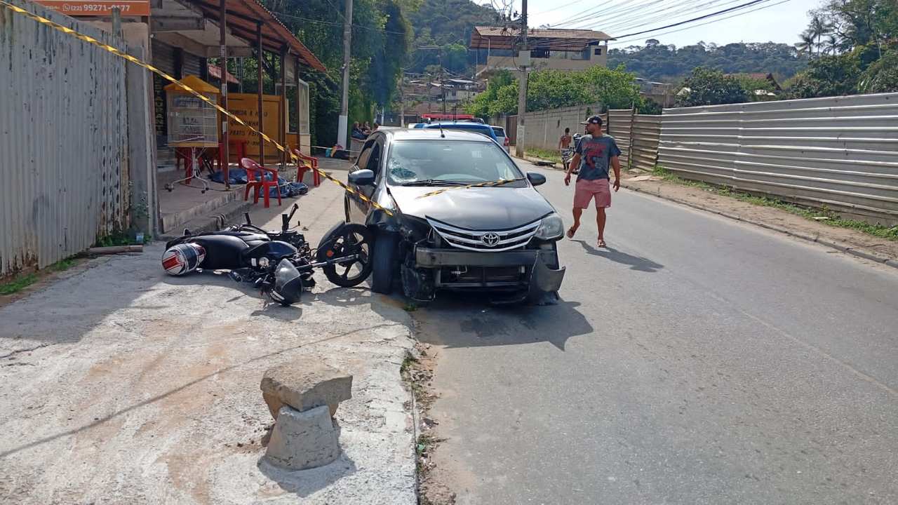 Acidente em Nova Friburgo: carro danificado e moto caída na rua, possivelmente envolvendo um catador de recicláveis.