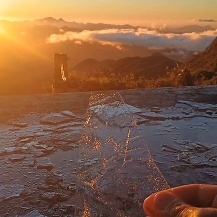 Amanhecer em Nova Friburgo com placas de gelo refletindo a luz do sol nascente.