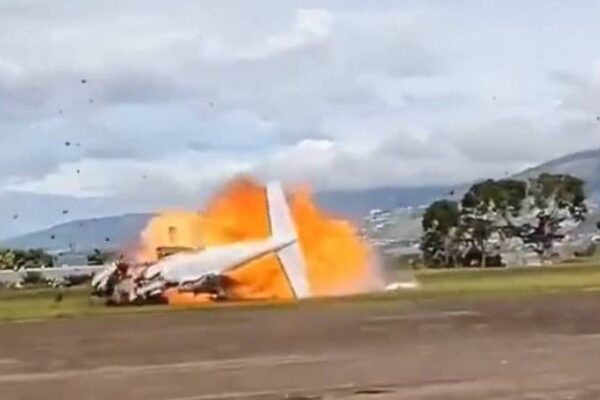 Avião em chamas após queda na Venezuela, mostrando fumaça e destroços.