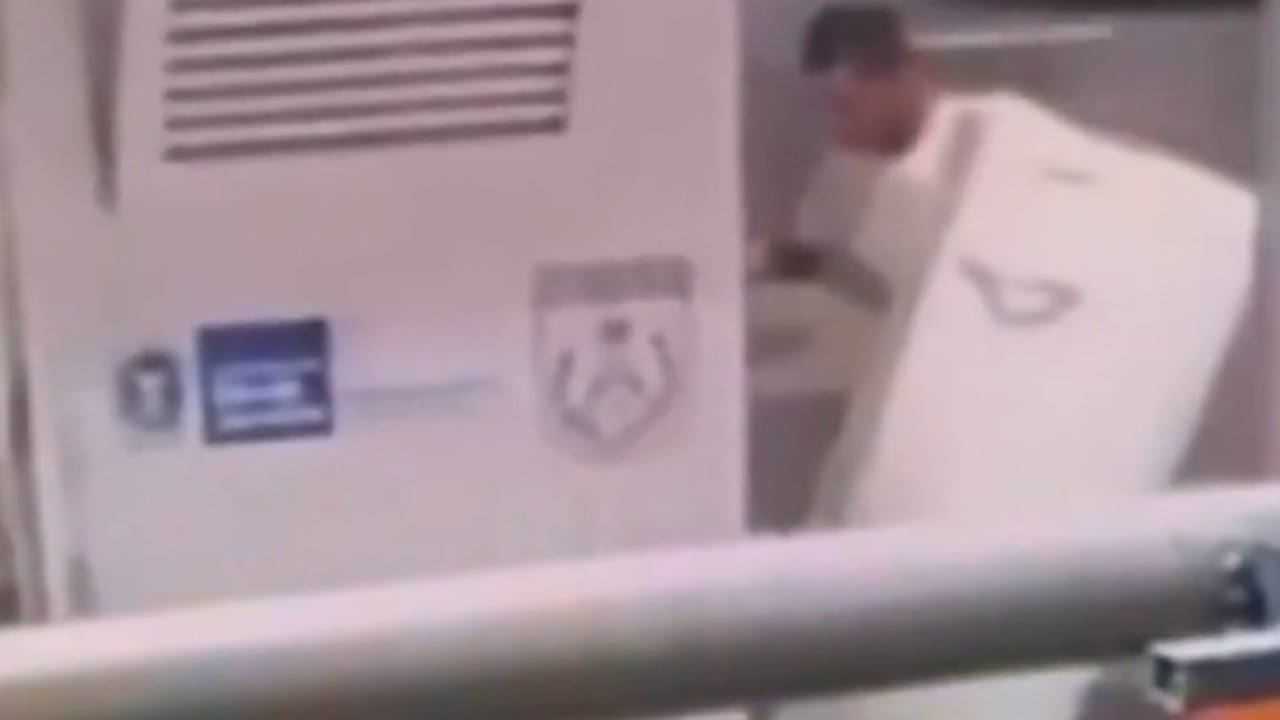 Bandido carregando geladeira roubada em posto policial.