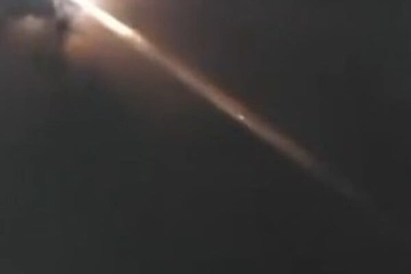 Bola de fogo cruzando o céu noturno, possivelmente lixo espacial reentrando na atmosfera.