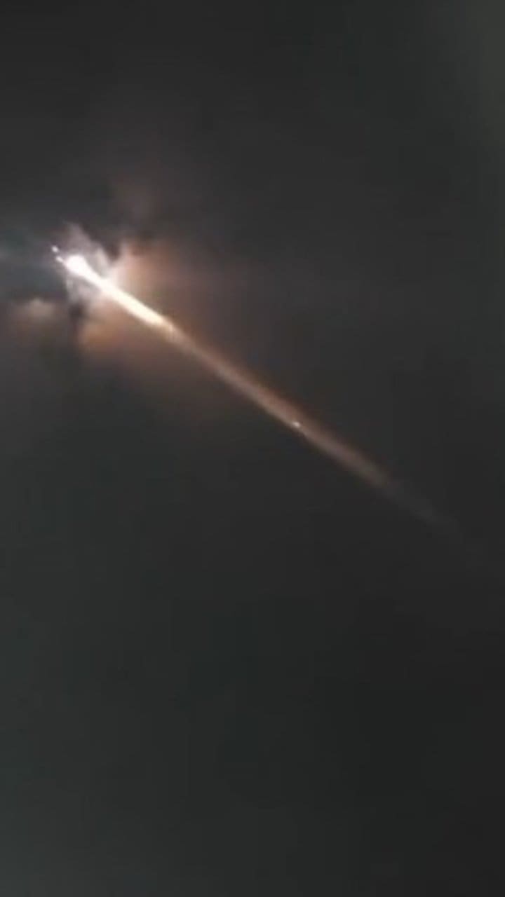 Bola de fogo cruzando o céu noturno, possivelmente lixo espacial reentrando na atmosfera.