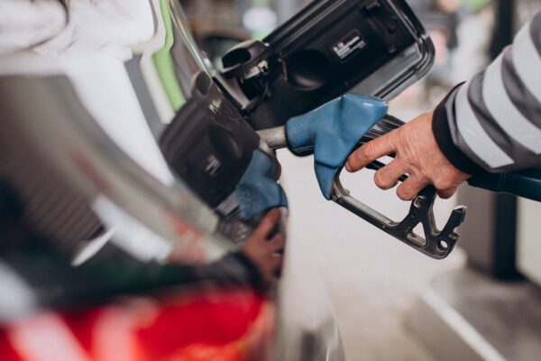 Bomba de gasolina abastecendo carro em posto.