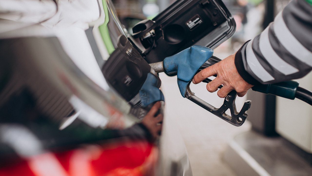 Bomba de gasolina abastecendo carro em posto.