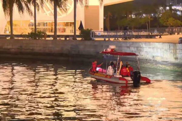 Bombeiros em bote na Baía de Guanabara durante busca noturna.