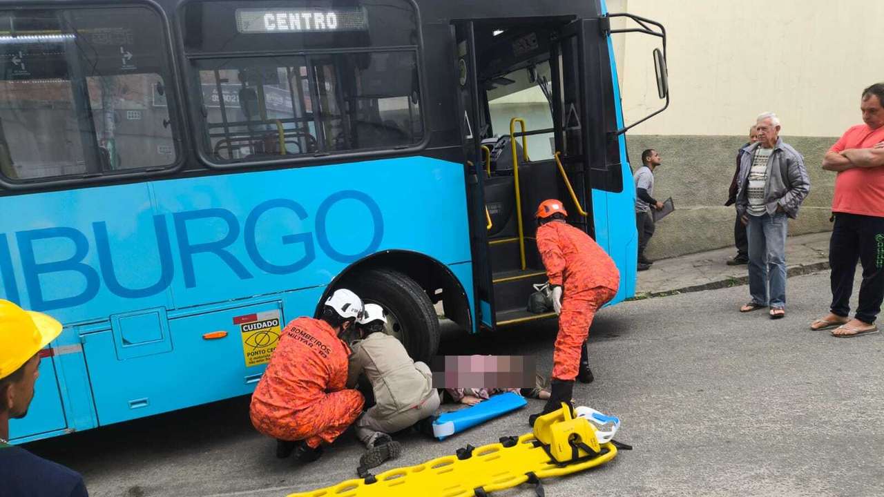 Bombeiros socorrem vítima de atropelamento em Nova Friburgo, próximo a ônibus azul.