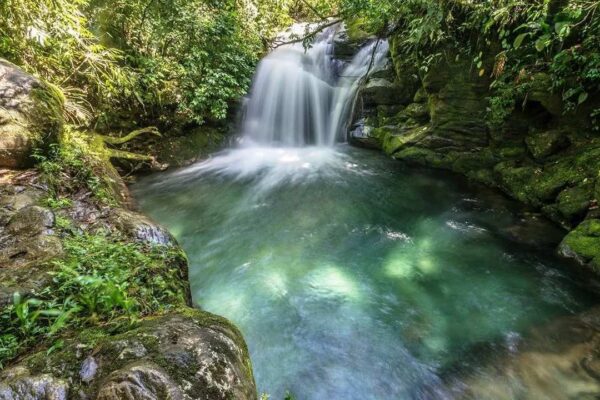 Cachoeira na Serrinha do Alambari, com água cristalina e vegetação exuberante.