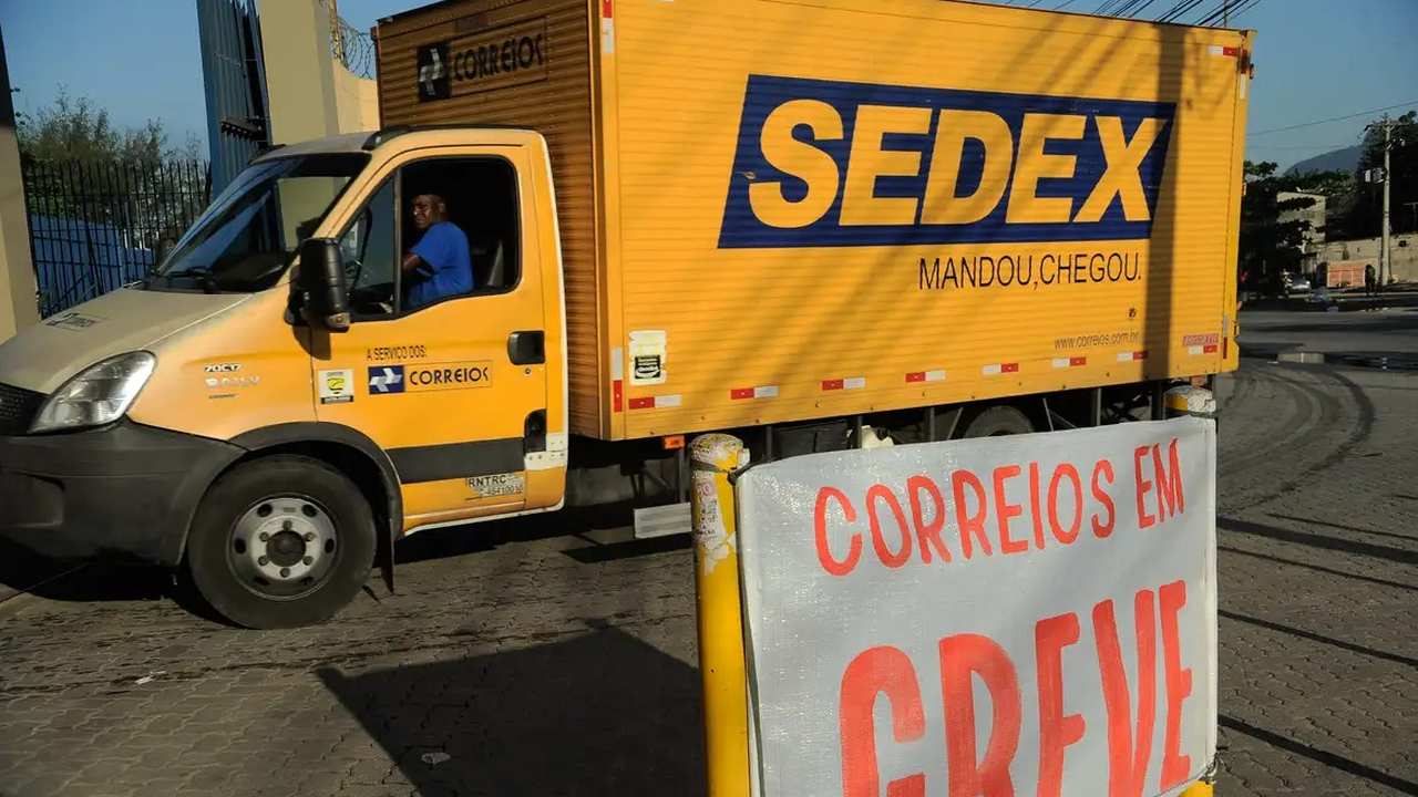 Caminhão dos Correios com a palavra SEDEX em destaque e aviso de greve.