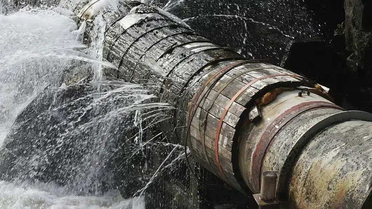 Canalização de água danificada com vazamentos, causando desperdício.