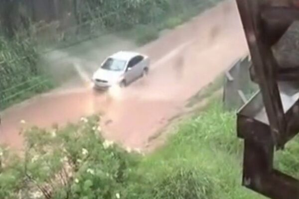 Carro atravessa rua alagada em temporal no Rio de Janeiro