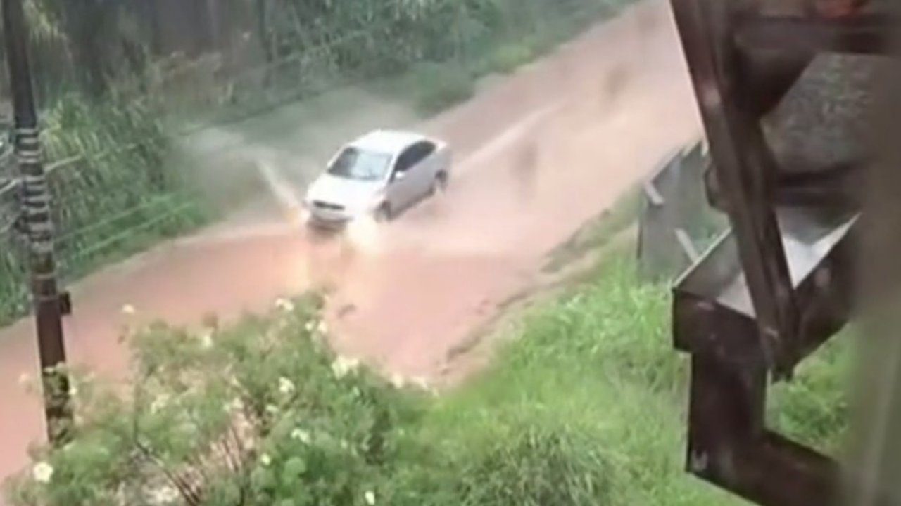 Carro atravessa rua alagada em temporal no Rio de Janeiro