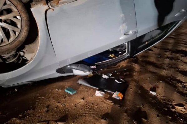 Carro capotado em acidente, com marcas de colisão.