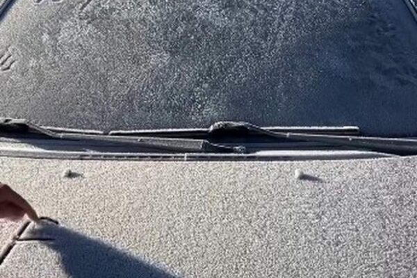 Carro coberto por geada em Itatiaia, mostrando o frio intenso e as condições climáticas.