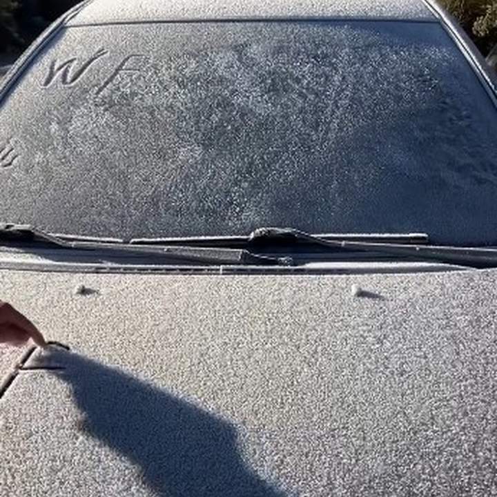 Carro coberto por geada em Itatiaia, mostrando o frio intenso e as condições climáticas.