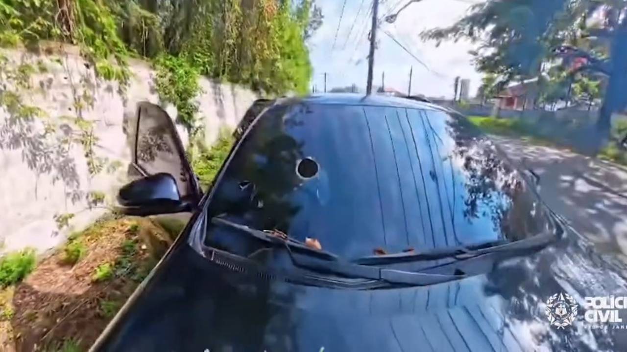 Carro com marcas de tiros, possivelmente apreendido em operação policial.