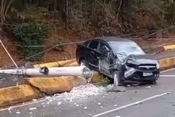 Carro preto danificado após colidir com poste na via expressa em Nova Friburgo, Brasil.