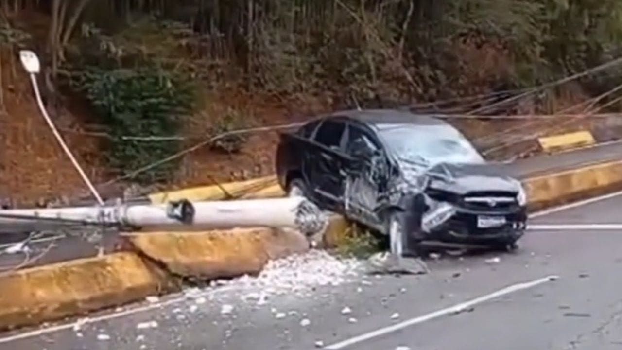 Carro preto danificado após colidir com poste na via expressa em Nova Friburgo, Brasil.