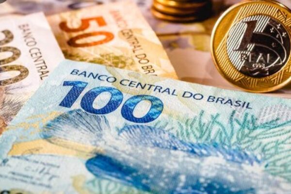Cédulas de dinheiro do Brasil e moeda de 1 real em foco.