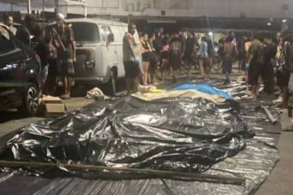 Cena no Complexo da Penha: corpos cobertos após operação policial no Rio de Janeiro, com pessoas ao redor.