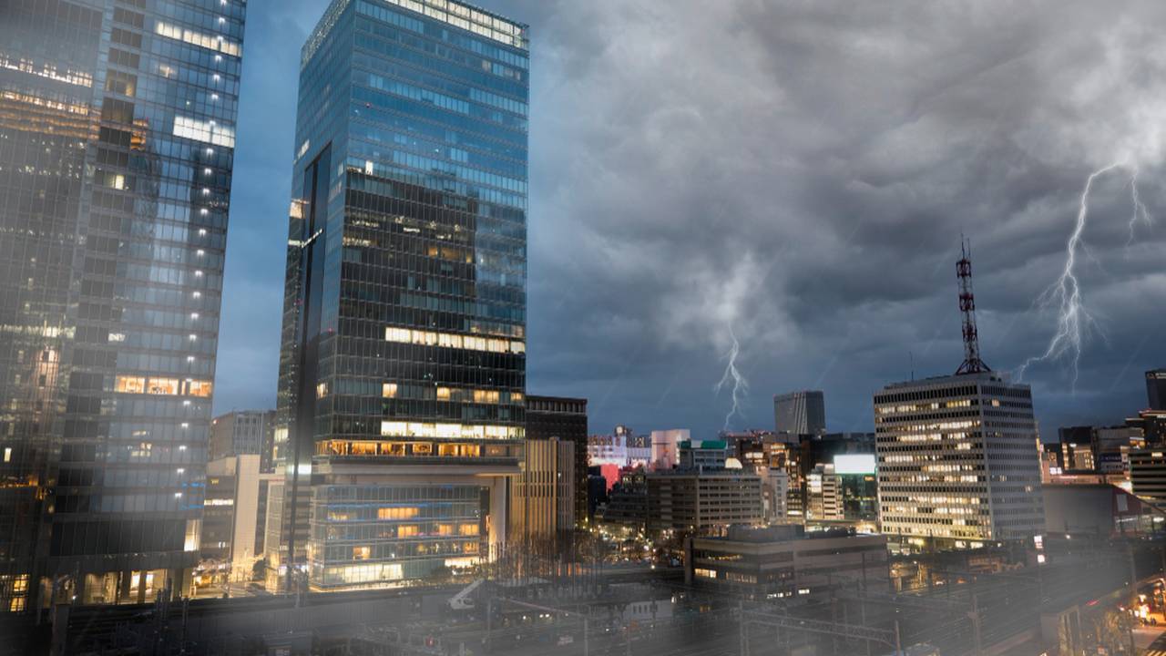 Céu nublado com raios sobre edifícios modernos em dia chuvoso no Rio de Janeiro.