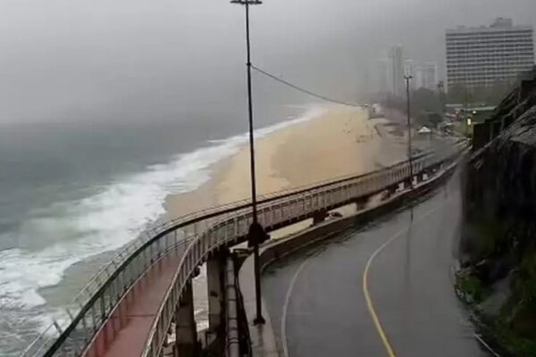 Ciclovia Tim Maia em dia chuvoso, com vista para a praia e edifícios ao fundo.