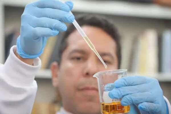 Cientista usando uma pipeta para analisar amostra de líquido em laboratório, com foco na contaminação.