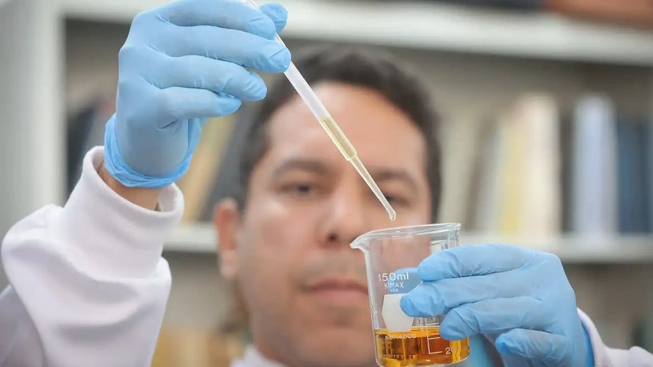 Cientista usando uma pipeta para analisar amostra de líquido em laboratório, com foco na contaminação.
