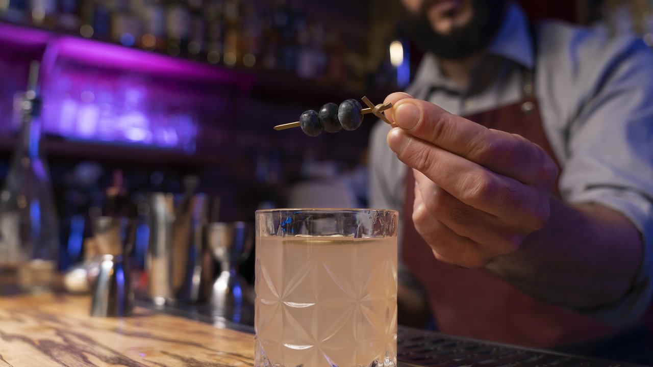 Cocktail sendo decorado com mirtilos. PF investiga bebidas adulteradas em SP.