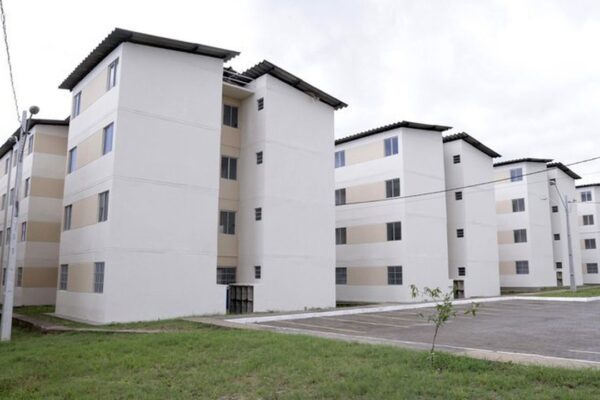 Conjunto habitacional Minha Casa Minha Vida em Olaria, com prédios de apartamentos brancos.