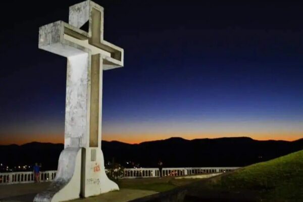 Cruzeiro no Mirante em Valença, com céu noturno e montanhas ao fundo.