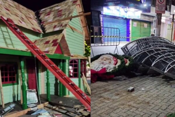 Decoração de Natal danificada: casa de madeira com escada e estruturas metálicas no chão.