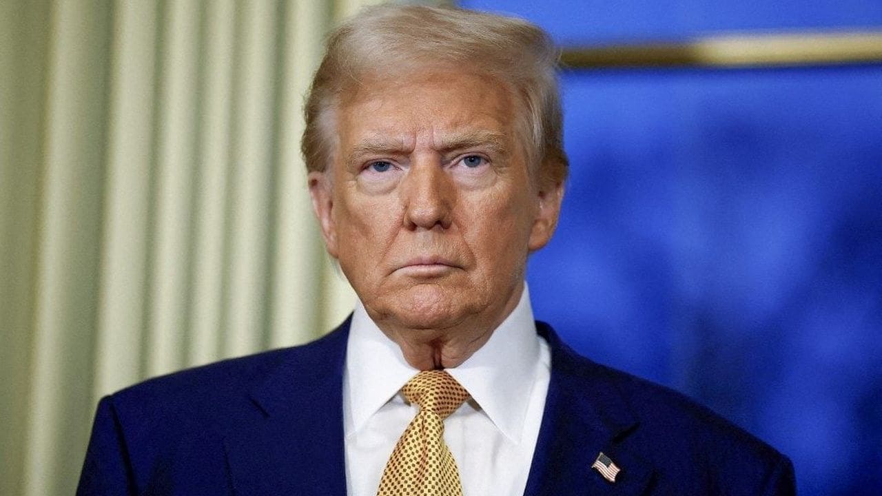 Donald Trump em um evento oficial, usando um terno azul e gravata amarela