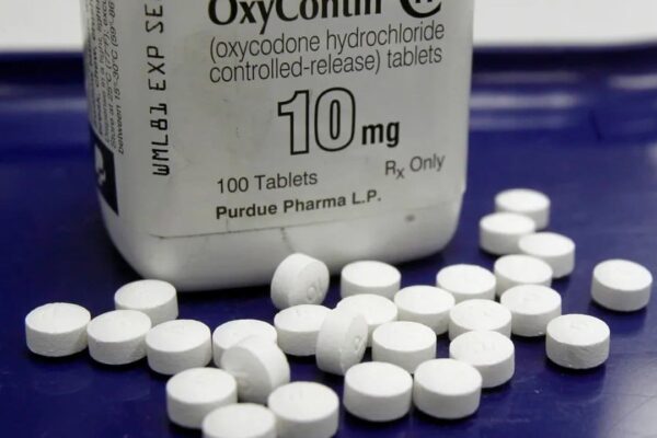 Embalagem de OxyContin 10mg com comprimidos. Medicamento para dor opioide, conhecido por sua relação com a crise de opioides.
