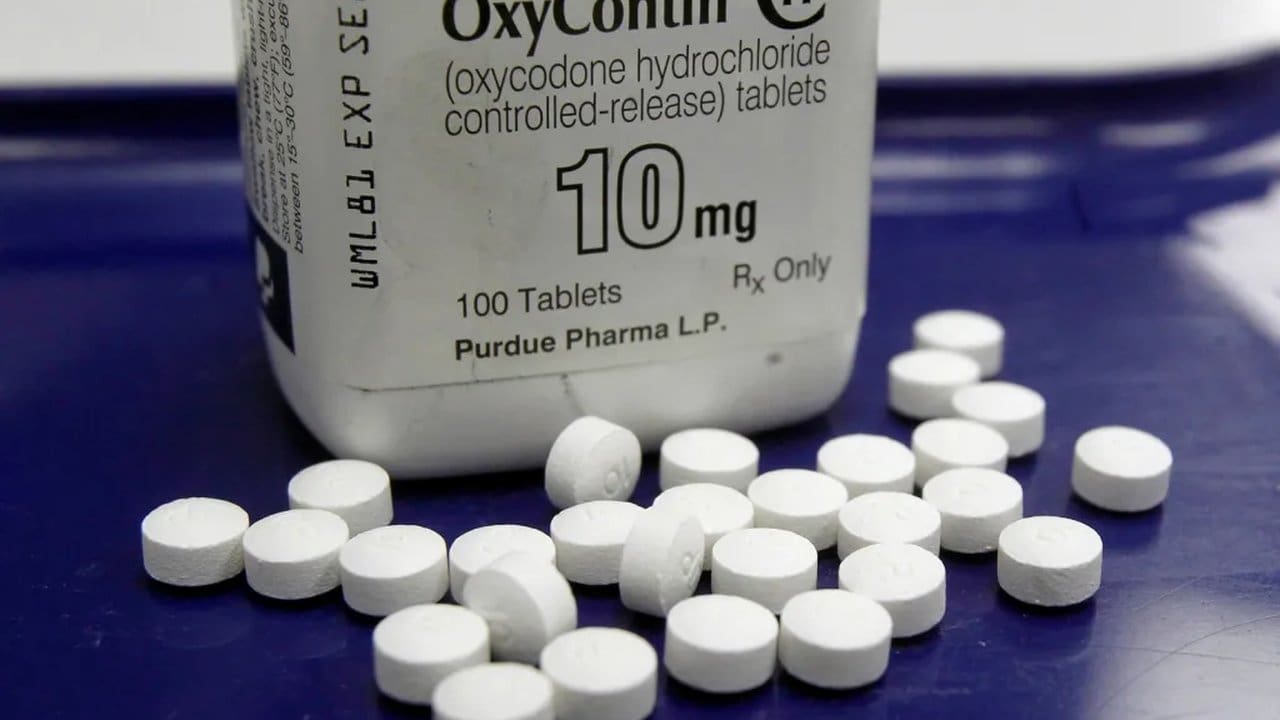 Embalagem de OxyContin 10mg com comprimidos. Medicamento para dor opioide, conhecido por sua relação com a crise de opioides.