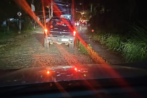 Engarrafamento noturno em Nova Friburgo com carro parado na via.