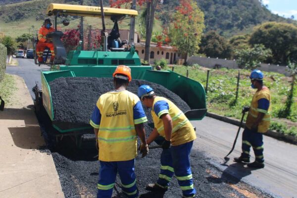 Equipe de obras realizando recapeamento asfáltico em via pública.