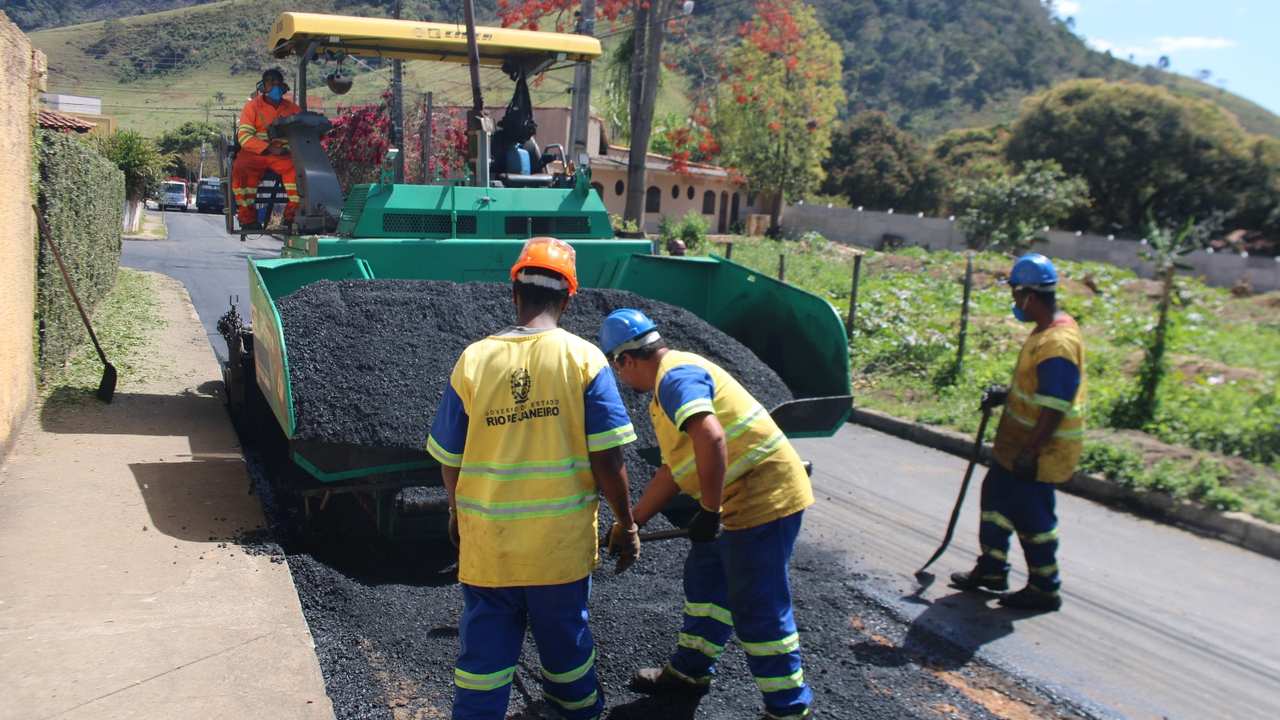 Equipe de obras realizando recapeamento asfáltico em via pública.