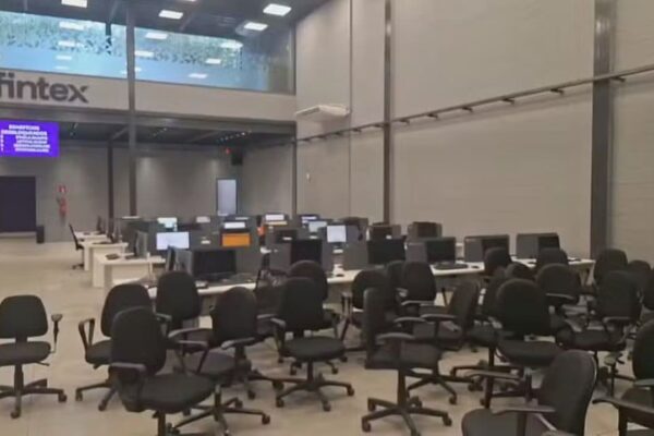 Escritório da Fintex fechado pela polícia na Barra da Tijuca, com computadores e cadeiras.