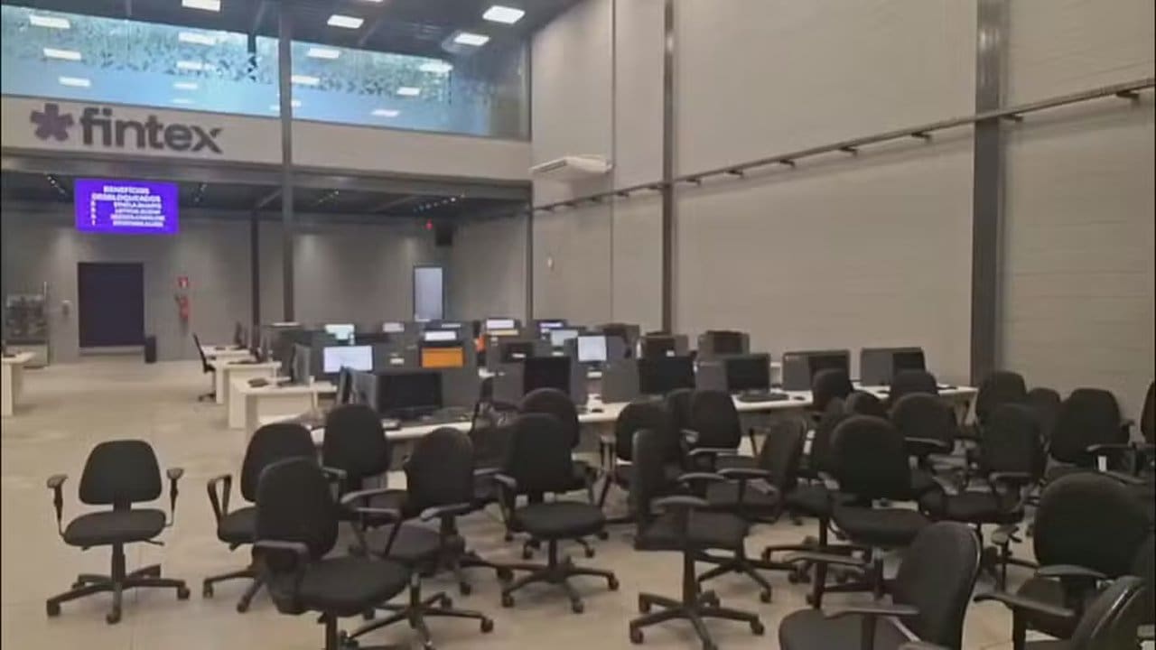 Escritório da Fintex fechado pela polícia na Barra da Tijuca, com computadores e cadeiras.