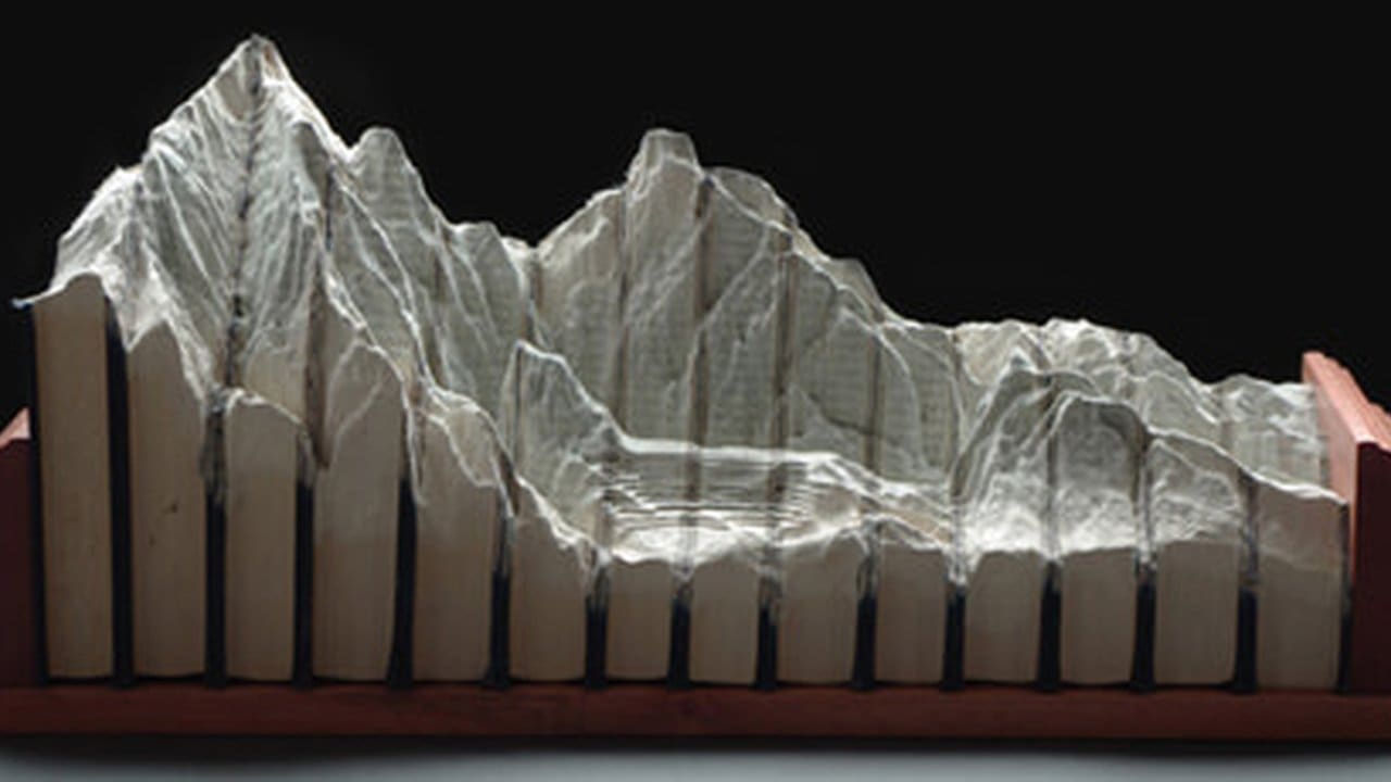 Escultura de montanhas feita de livros por Guy Laramee.