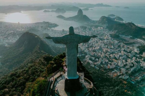 Estátua do Cristo Redentor no Rio de Janeiro, com vista panorâmica da cidade e alerta na população.