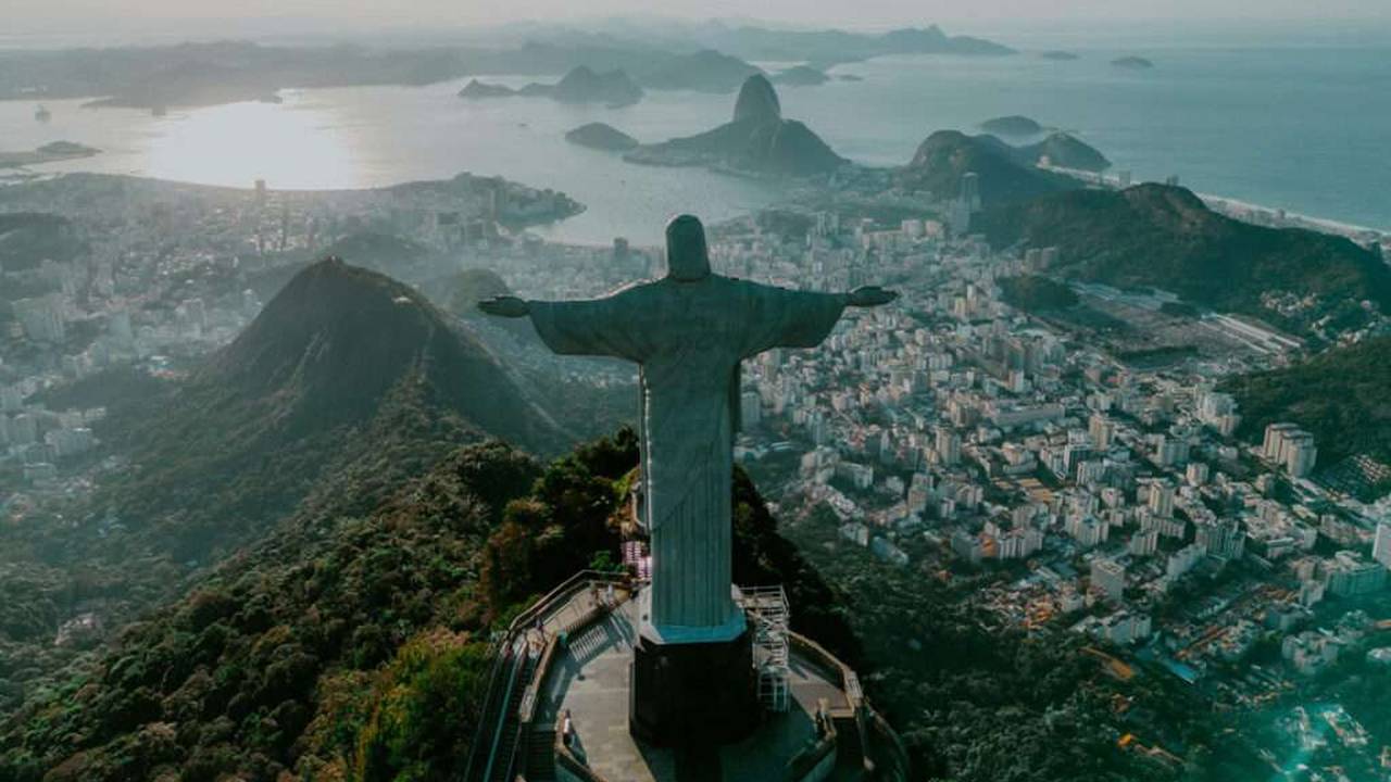 Estátua do Cristo Redentor no Rio de Janeiro, com vista panorâmica da cidade e alerta na população.