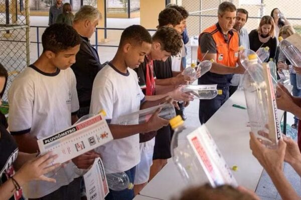Estudantes em oficina de proteção e defesa civil construindo pluviômetros.