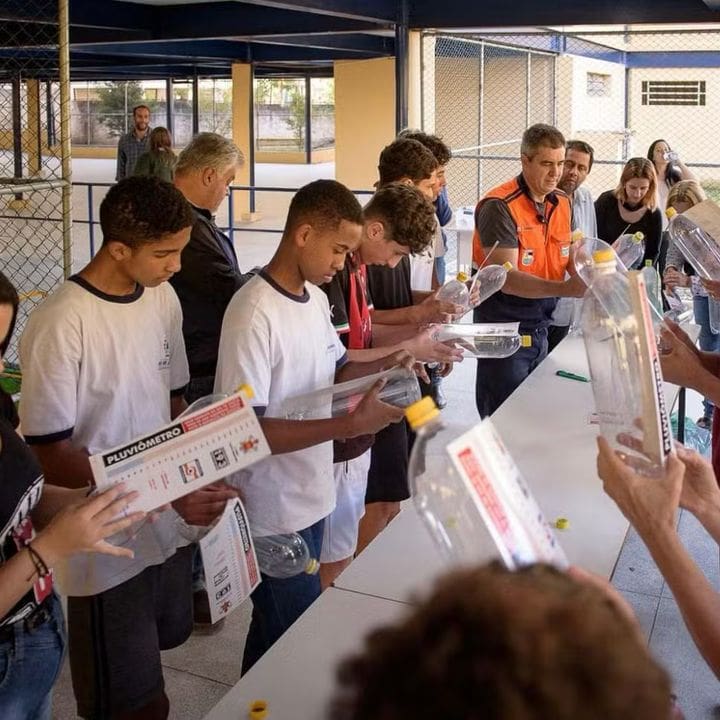 Estudantes em oficina de proteção e defesa civil construindo pluviômetros.